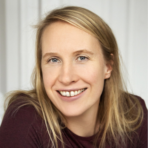 Porträt Foto einer Frau. Mittellange, blonde Haare zum Zopf gebunden.